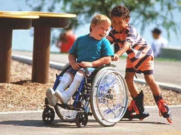 мальчик на роликах везет мальчика на коляске